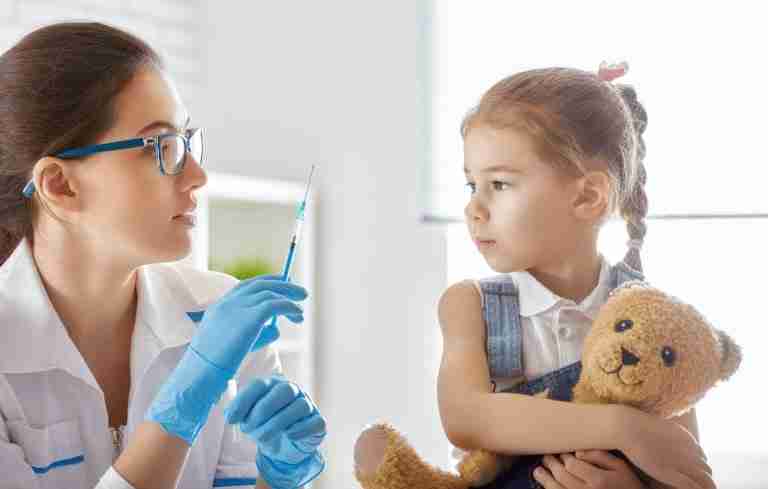 Clinician preparing an immunization with a child
